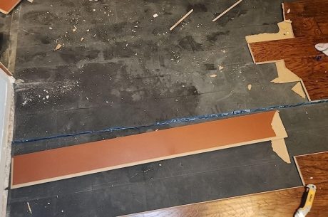 Wet damaged vinyl flooring from water heater leak.