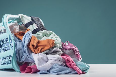 A heap of clothes in different colors and a rubber basket