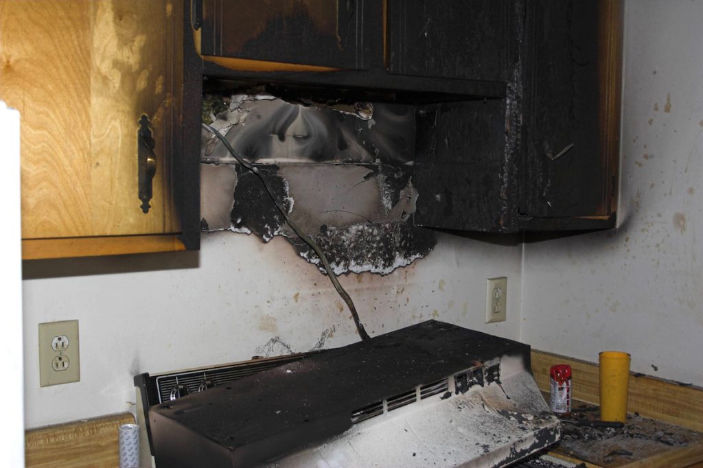 Fire damage to a kitchen including damage to a stove and microwave