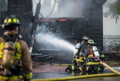 firefighters spraying water to put out a house fire