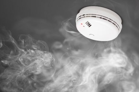 Smoke surrounding smoke detector. Understanding the different smoke detector types can protect your home.