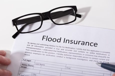 A flood insurance policy with a pair of glasses placed on it