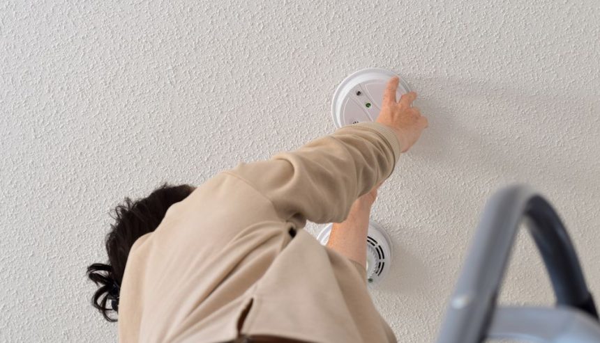 A woman practices smoke alarm maintenance in her Atlanta home