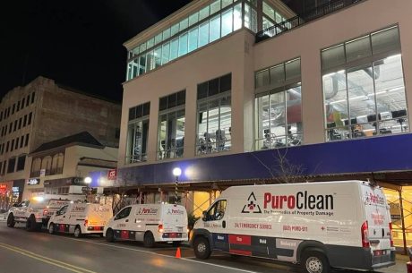 PuroClean vans outside of building during commercial water loss restoration work.