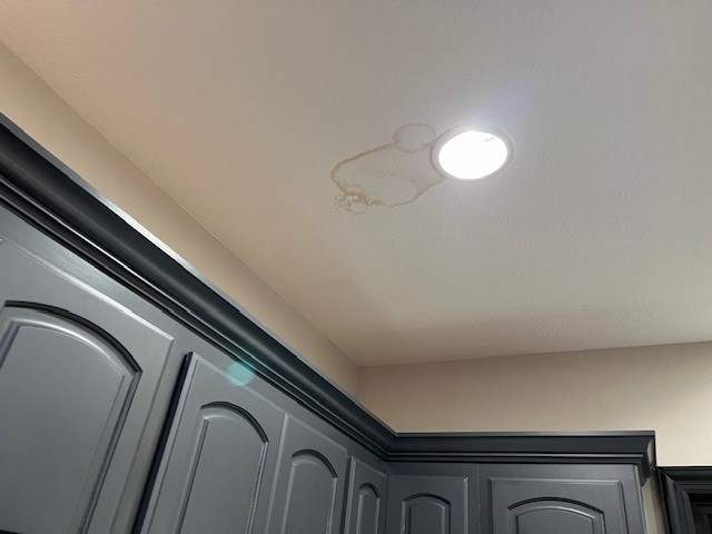 The kitchen ceiling suffered damage from the primary bathroom leak.