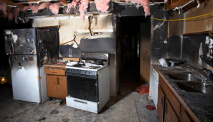 Badly damaged kitchen appliances ready to throw out after a house fire.