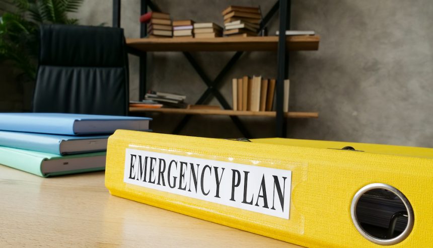 Emergency preparedness plan in a yellow folder on a desk.