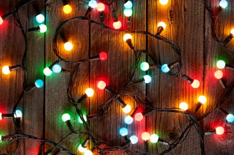 Christmas colorful lights on wooden table. holiday decoration safety tips