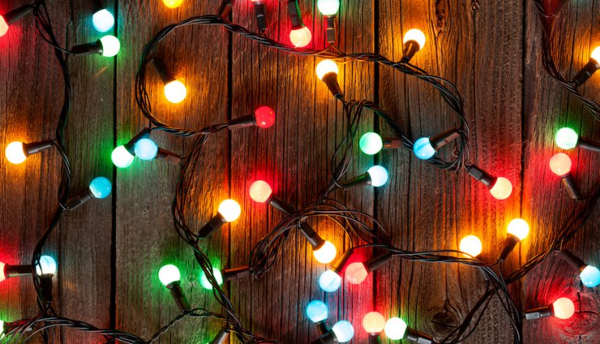 Christmas colorful lights on wooden table. holiday decoration safety tips