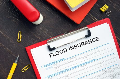 A clipboard with a flood insurance policy on it