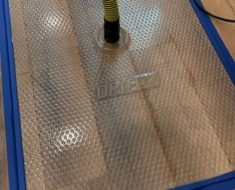 Injectidry water extraction mat set on homeowners floor in order to extract water from between tiles and save the flooring.