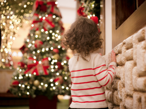 child looking at lighted christmas tree - ready for fire safety for kids tips