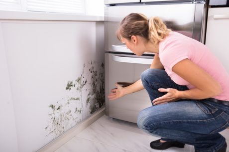 A woman dealing with mold damage in her kitchen