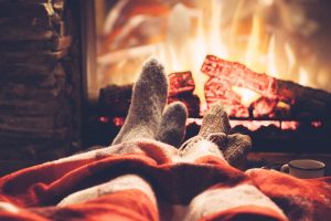 Couple warms their sock-covered feet by the fire