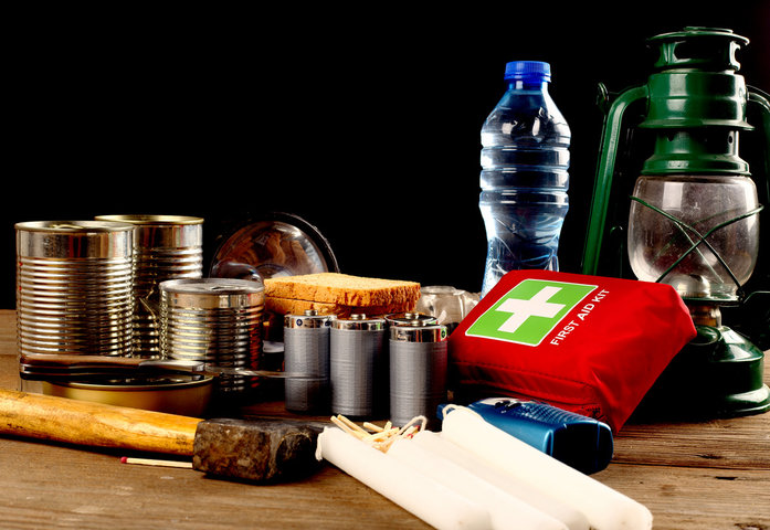 An emergency kit with bottled water and canned goods.