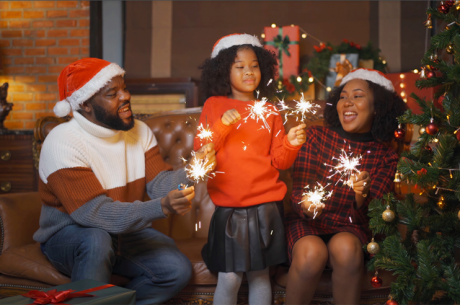 a family with sparklers and a lit Christmas tree: fire safety for kids