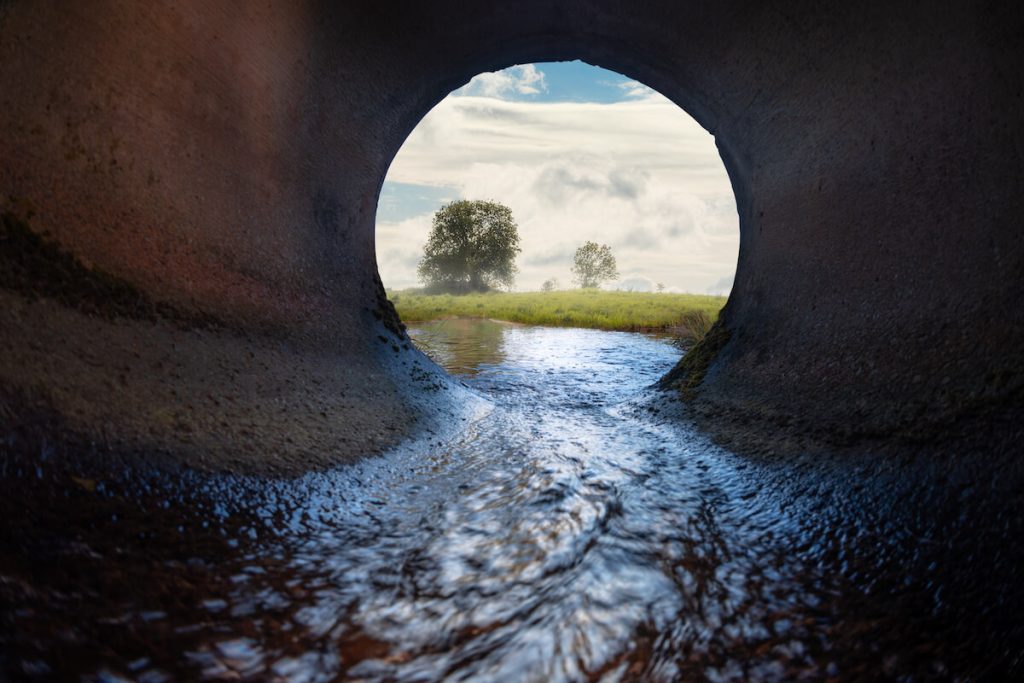 inside of a sewer pipe with flowing water 