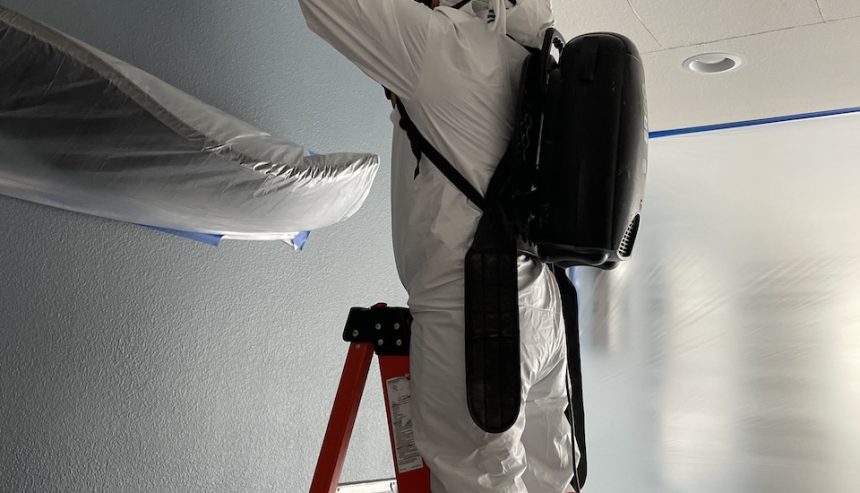 A technician inspecting the water damage from a water heater leak.