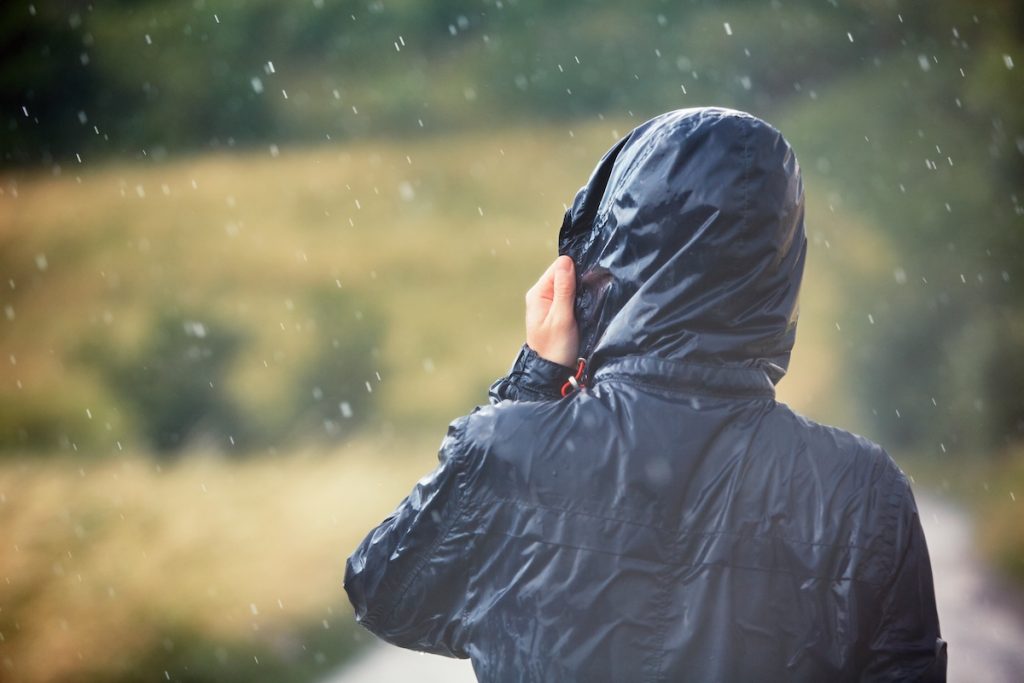 A person walking in the rain during a thunderstorm