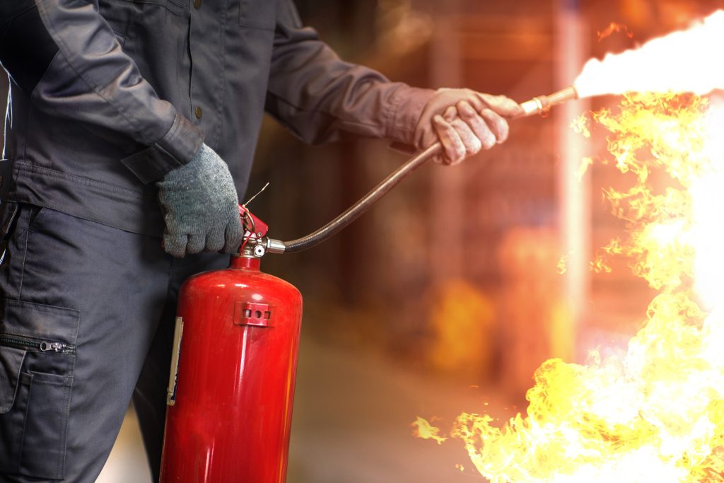 fireman trying to put fire out with fire extinguisher