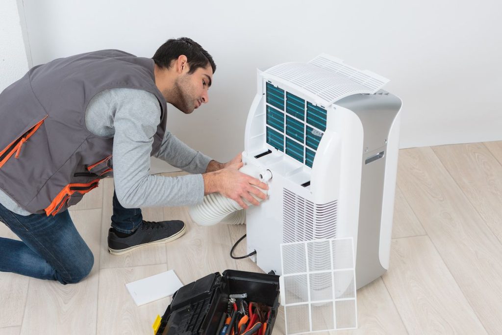 a technician installing a dehumidifier in a home