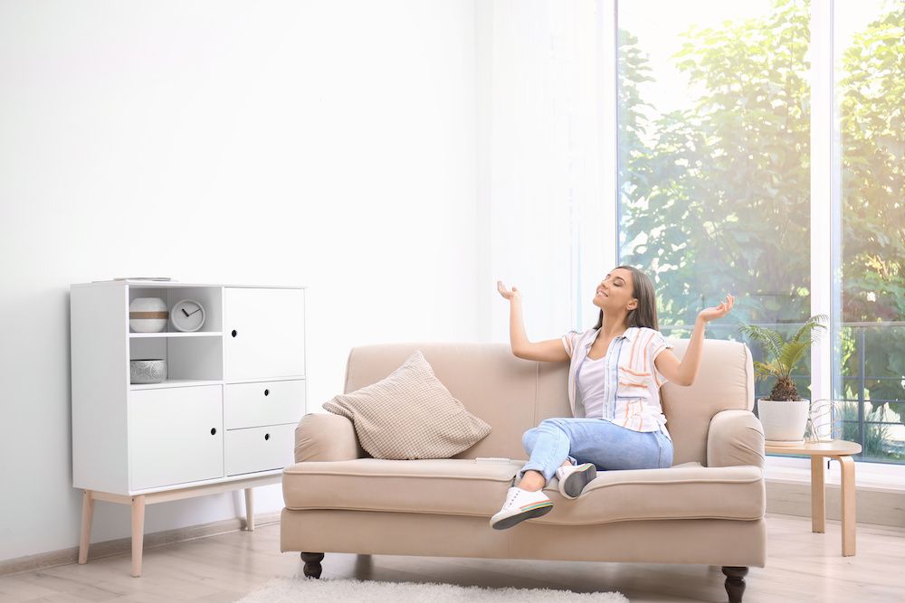 happy woman at home sitting on a brown couch