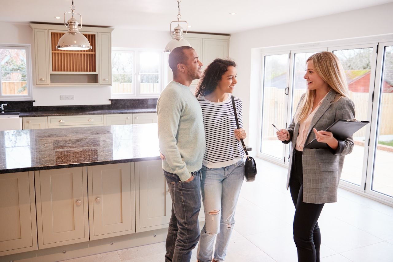 young couple with real estate agent in a home