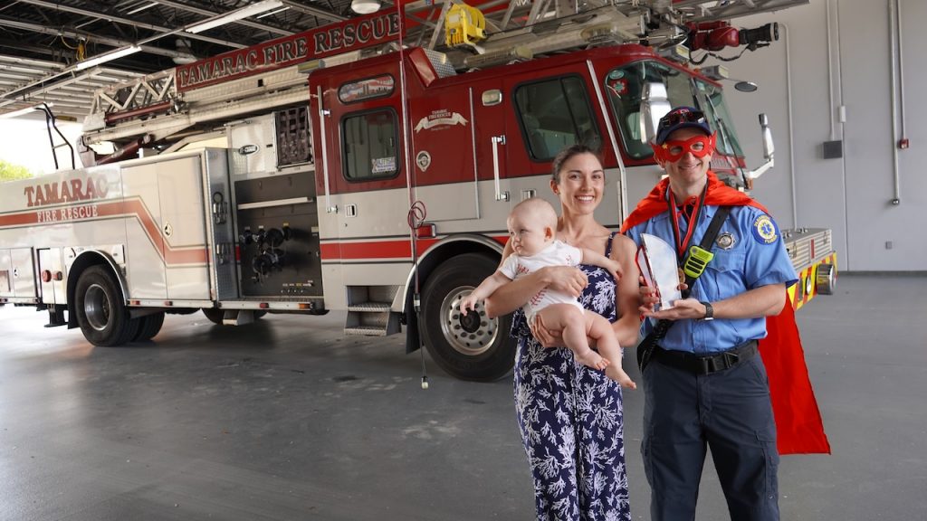 James poses with his son and wife as he is honored in PuroClean's annual Superhero Day Campaign.