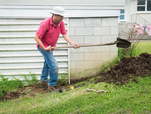 man digging with a shovel on a slope