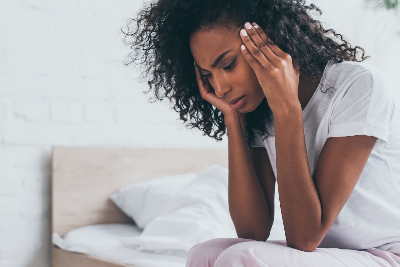 woman getting out of bed feeling unwell