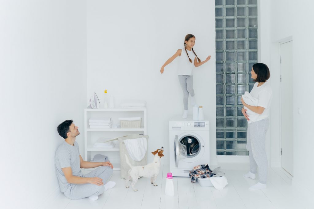 A family with their puppy enjoys the clean room where they did the laundry.