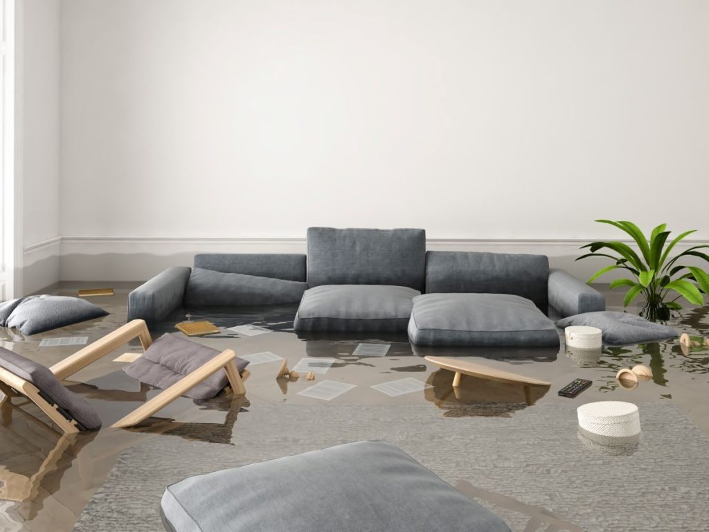 couch and chairs in flooded living room. Spring flooding prevention can help you avoid this scenario,