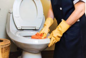 Home Organization - Someone cleaning toilet with yellow rubber gloves