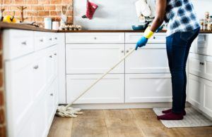 Home Organization - man cleaning kitchen with mop