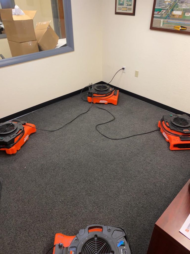 Drying equipment set up in office during water damage restoration from overflowing toilet.