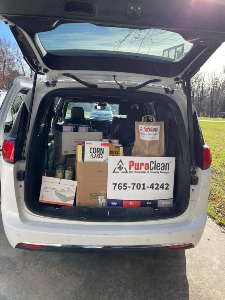 Bags of food loaded in trunk of van for PuroClean food drive.