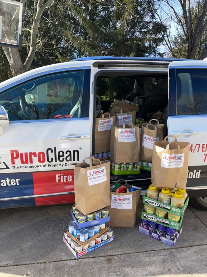 Bags of food loaded in trunk of van for PuroClean food drive.