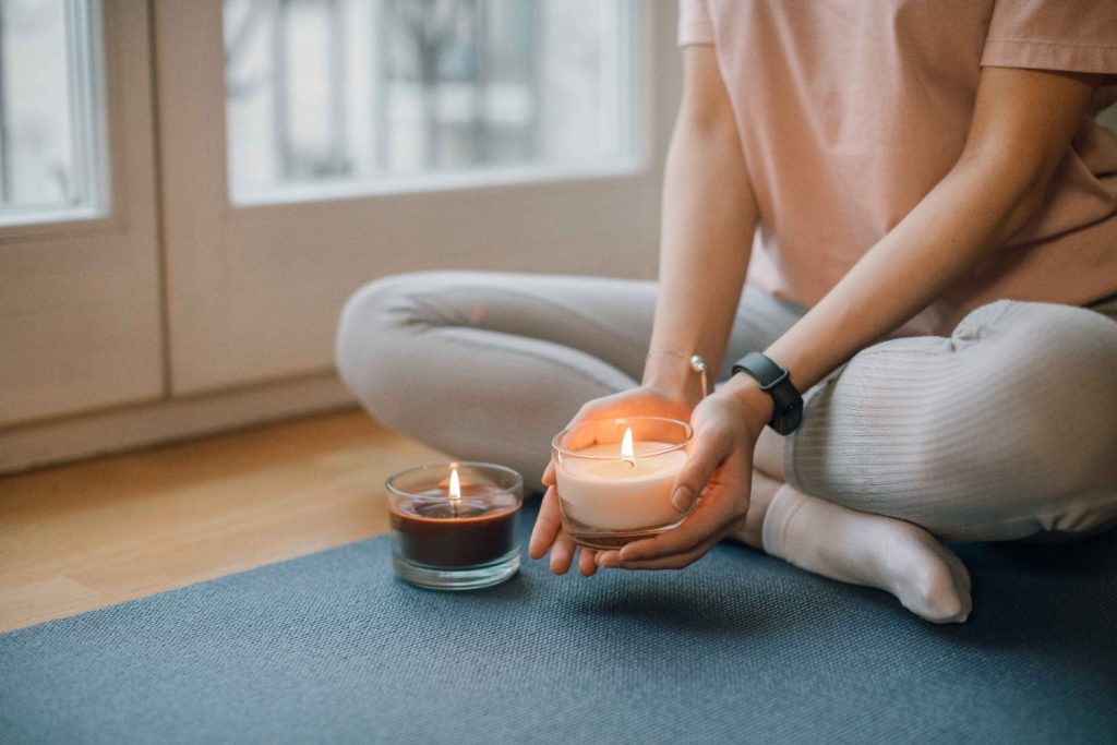 A person holding a burning candle